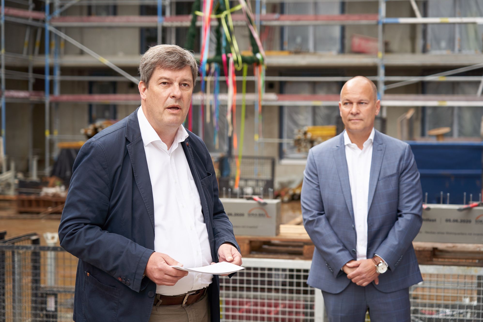 AOC-Vorstand Till Schwerdtfeger (rechts) und Gregor Asshoff, Vorstand SOKA-BAU, beim Richtfest. Copyright: AOC Immobilien AG / Tom Dachs.