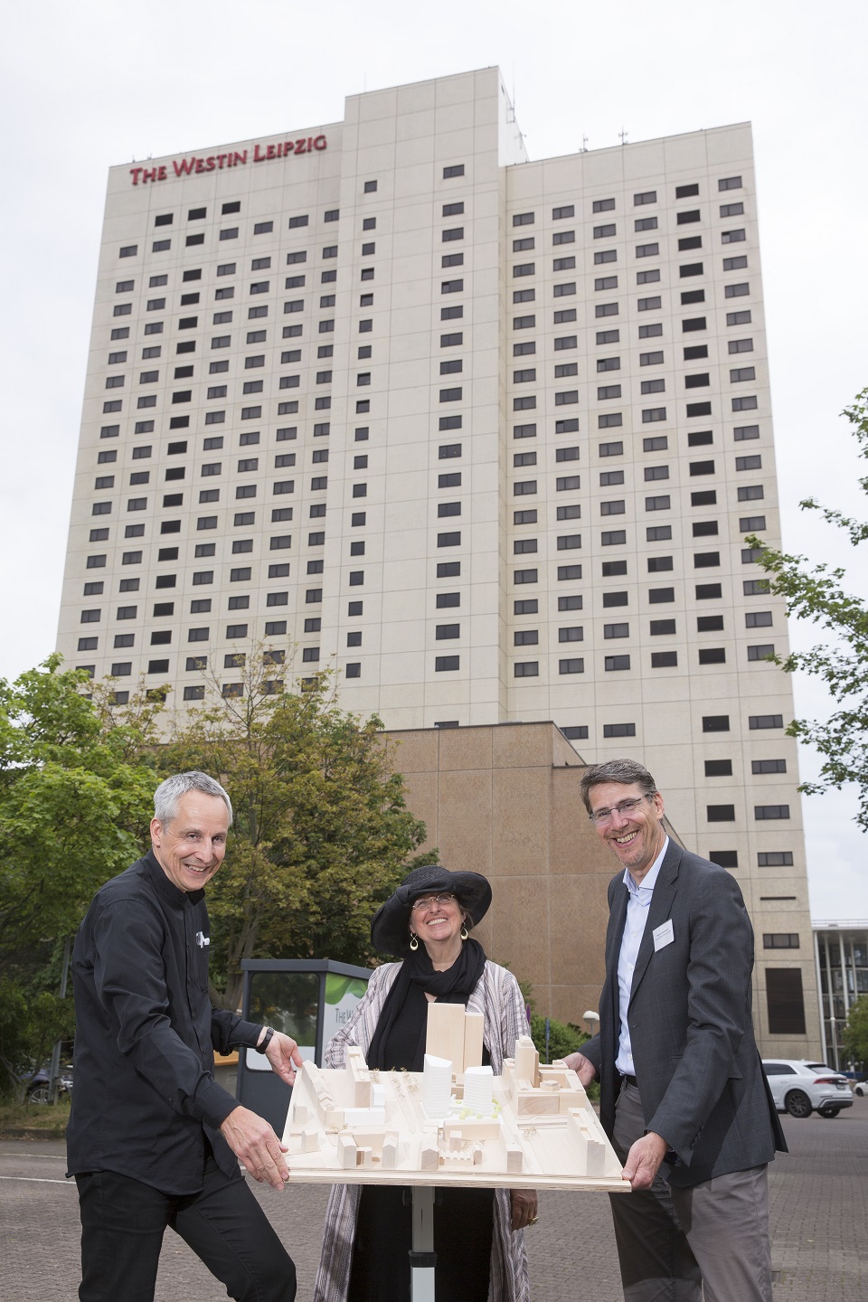 Prof. Jörg Springer, Dorothee Dubrau und Norman Weichhardt (v.l.n.r.) mit dem Siegermodell von HENN Architekten vor dem Westin-Hotel. Quelle: Covivio / Stefan Hoyer. 